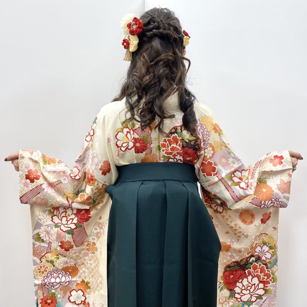 キモノモード町田店の卒業袴を着たお客様コーディネートの写真。両袖を広げた後姿。袴に合わせたハーフアップの髪型につまみかんざしをつけている写真。