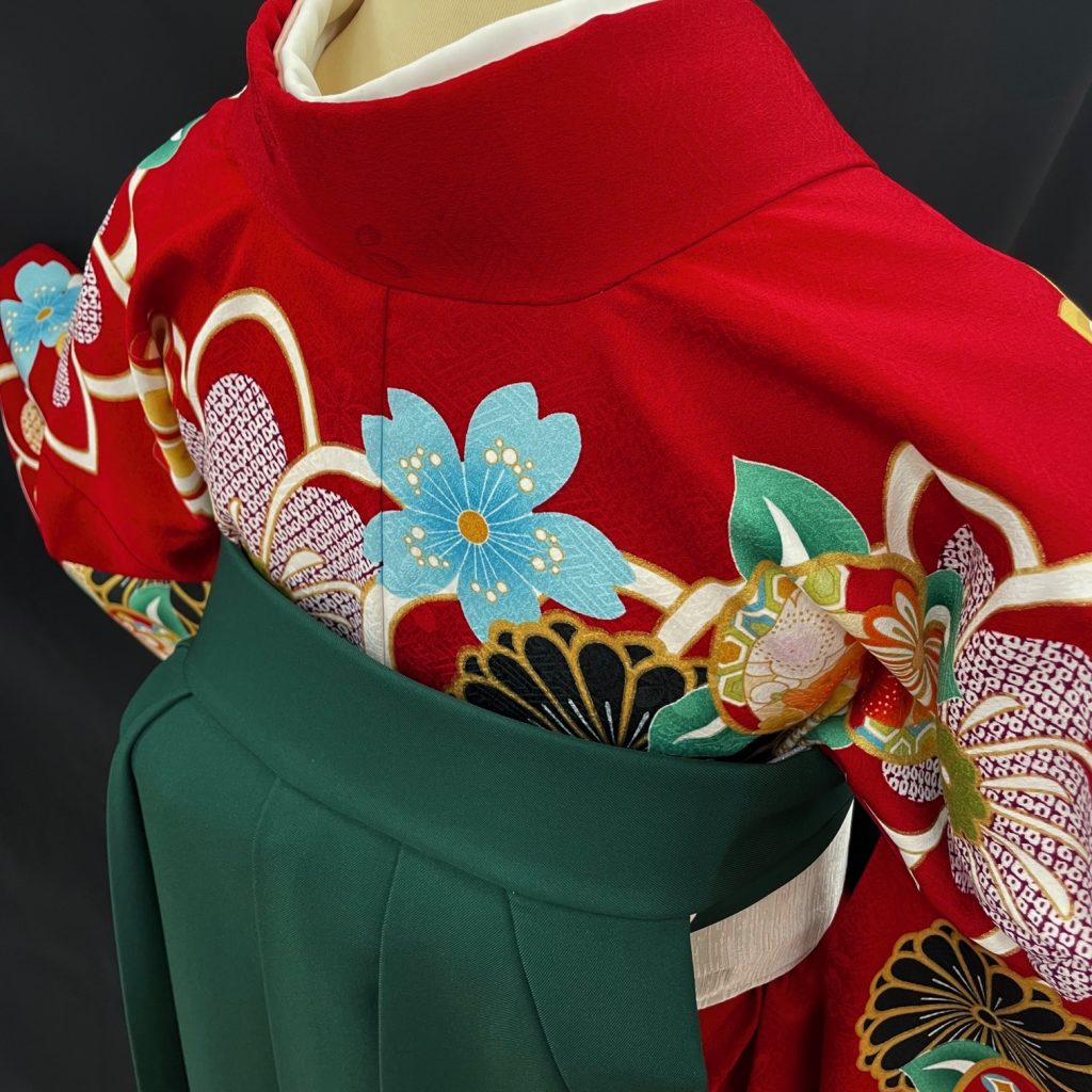 赤い着物に緑の袴を合わせた袴の後ろ姿