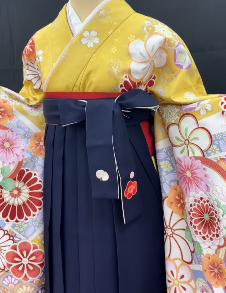 両袖を広げる黄色い着物に紺の袴を合わせた卒業袴のコーディネート