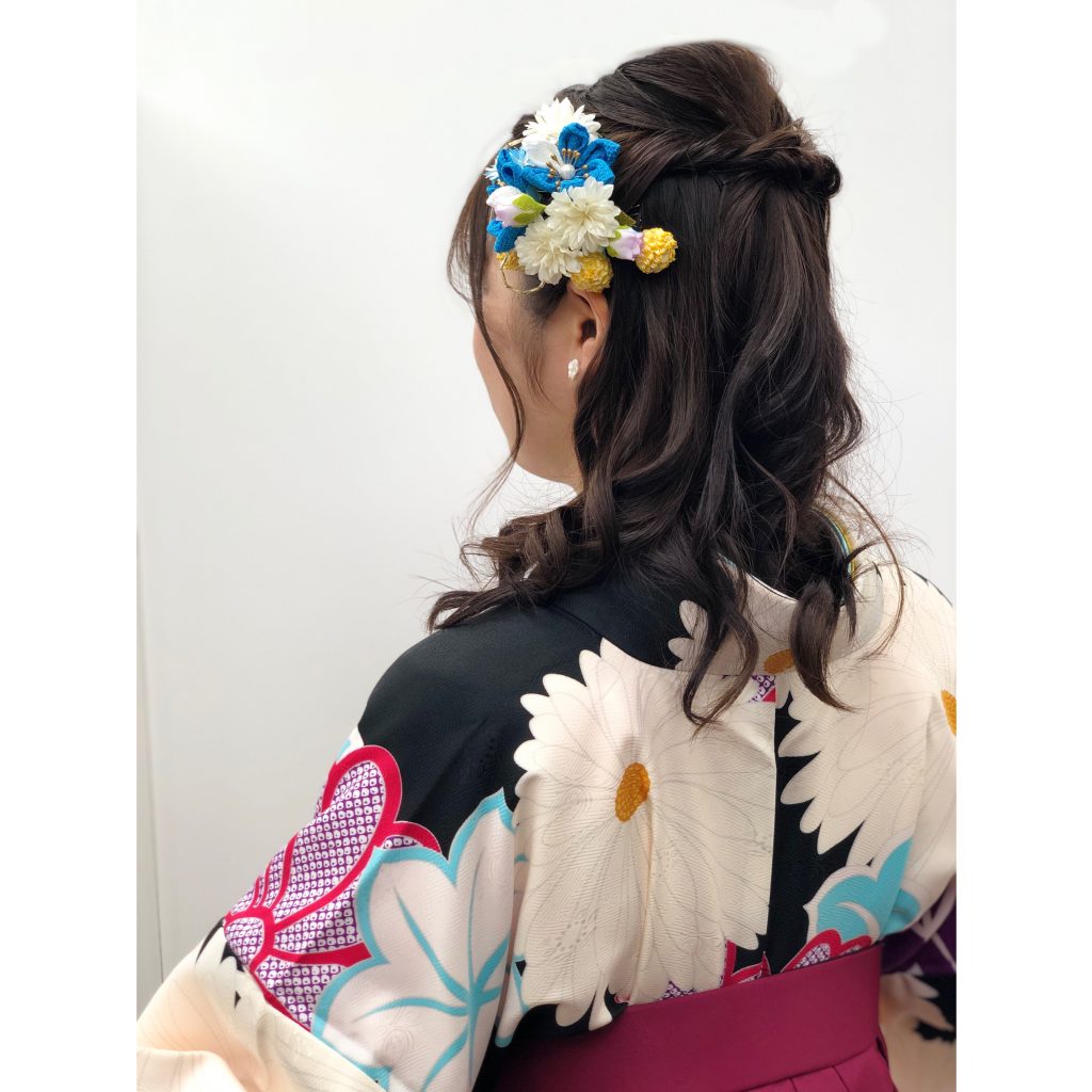 キモノモード町田店の卒業袴のレンタルのお客様コーディネート。 二尺袖といわれる、黒い着物を着たコーディネート写真。袴に合わせたハーフアップの髪型に水色の髪飾りをつけています。