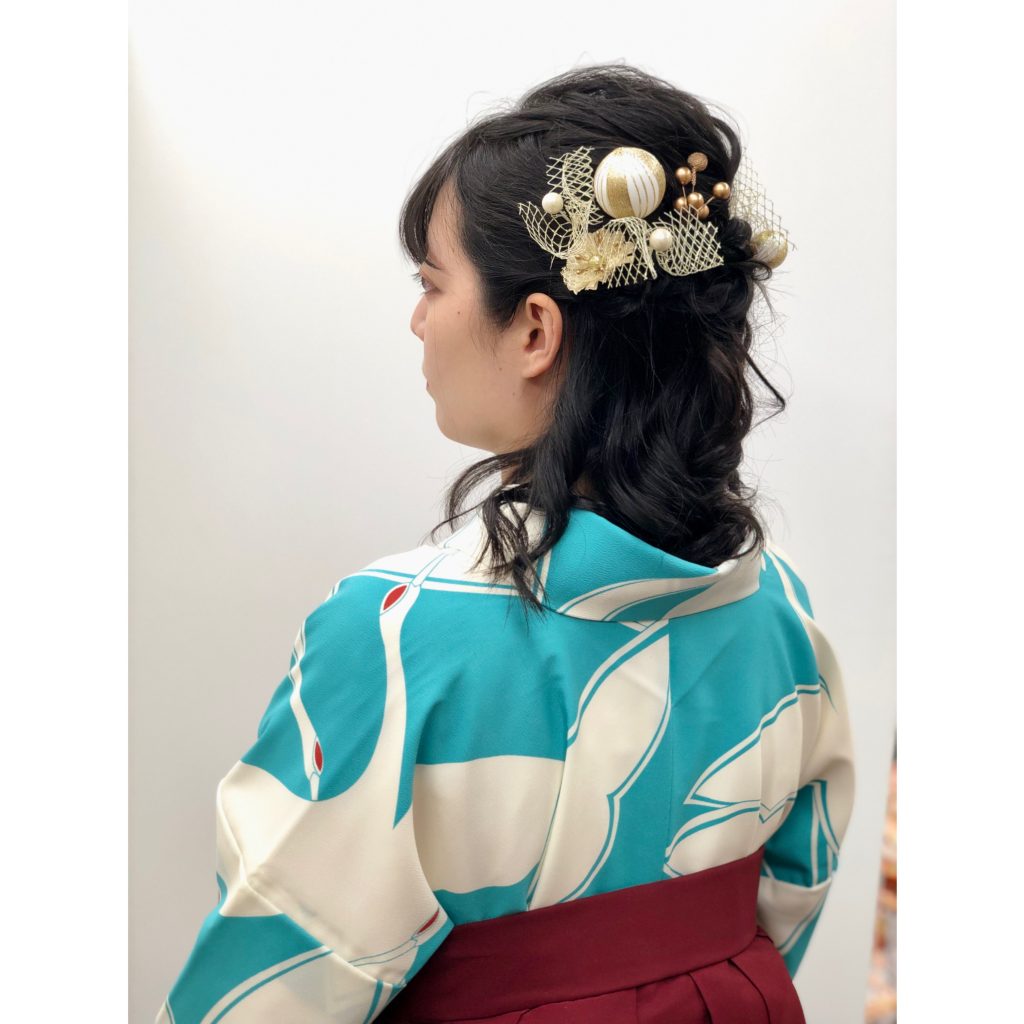 袴の後姿に和玉とチュールリボンの髪飾りを付けた写真。水色の着物に白い丹頂鶴の柄が描かれています。