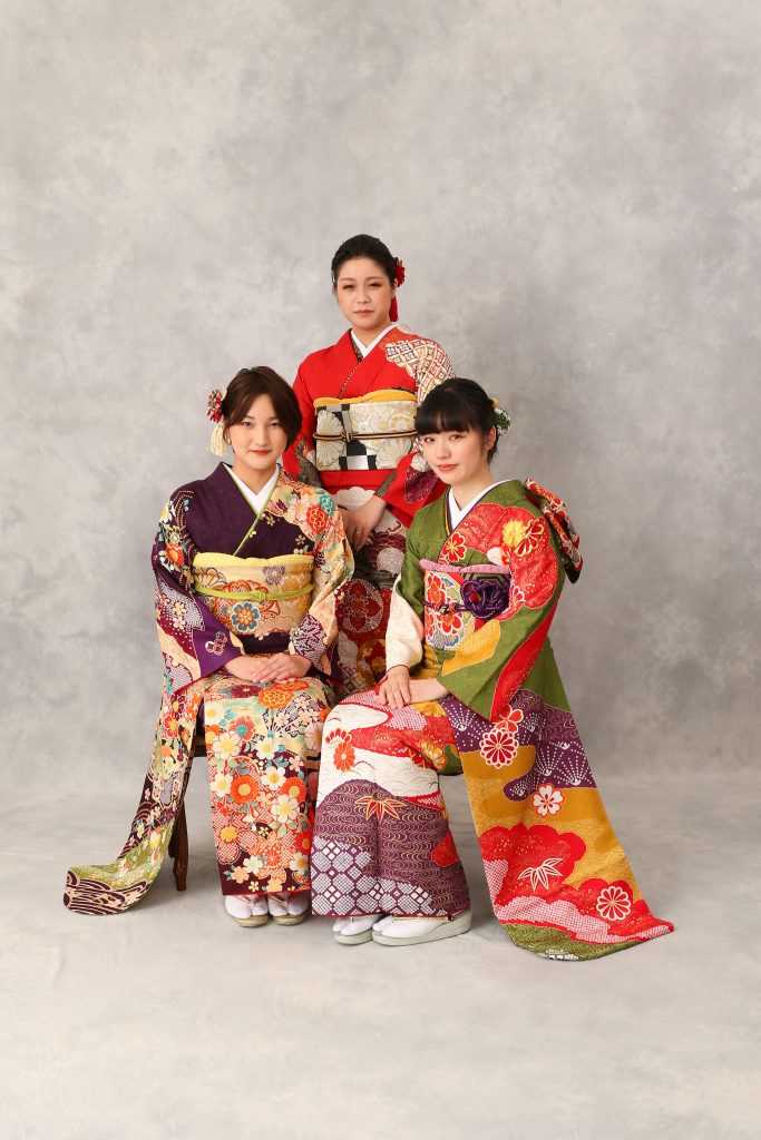 抹茶の振袖、紫の振袖、赤の振袖を着た3人の女性の前撮り記念写真